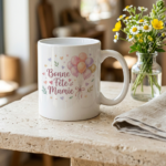 White ceramic mug with pastel balloons and the French message 'Bonne Fête Mamie' on a light countertop.