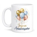 White ceramic mug featuring pastel balloons and confetti with the French birthday message 'Joyeux Anniversaire' in gold and navy script.